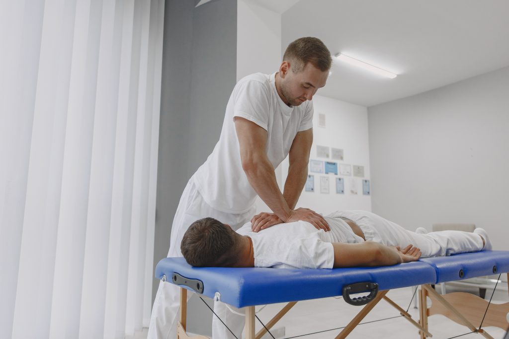 Male physiotherapist massaging man's back - رؤية - رؤية